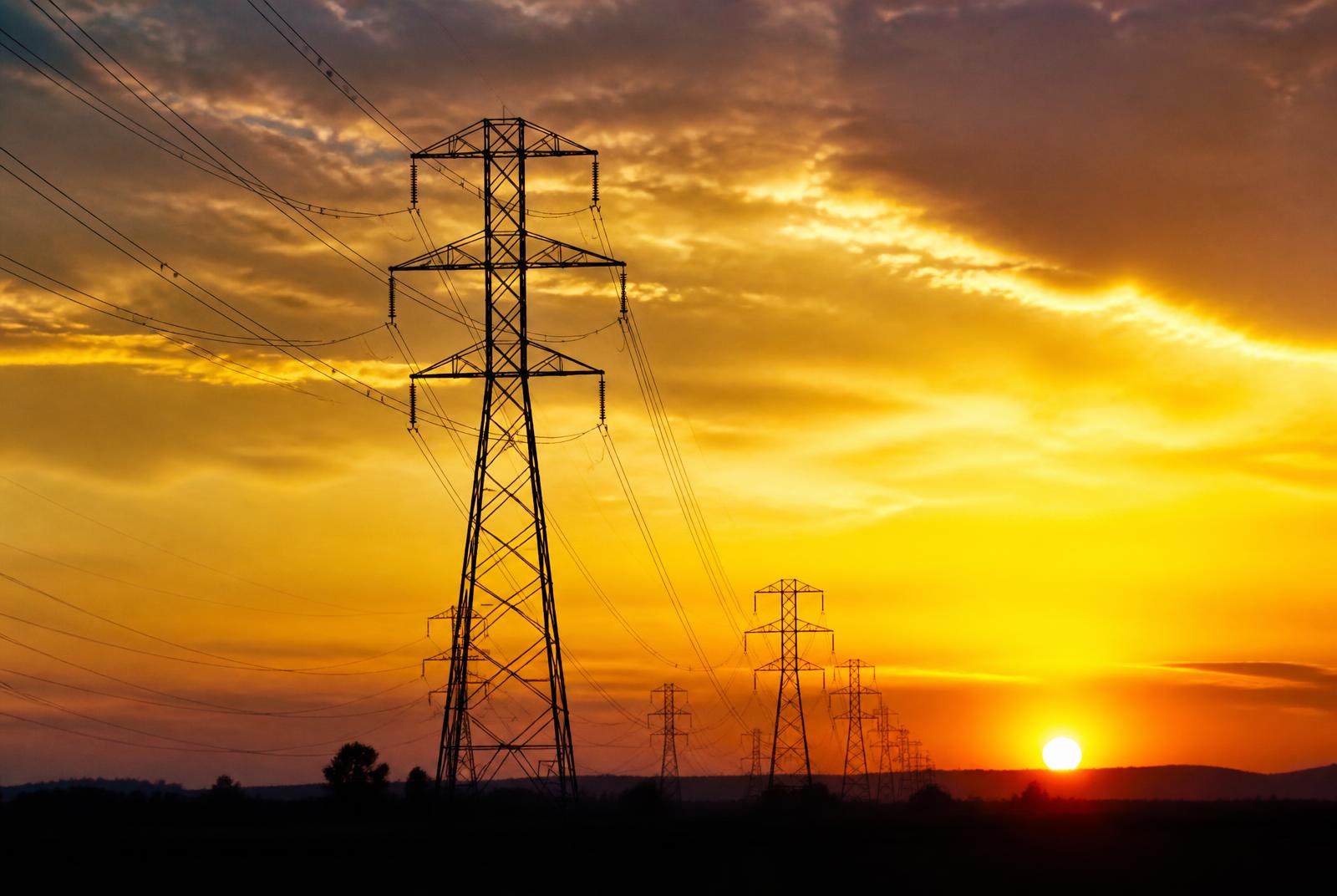 Transmission towers at sunset with light trails
